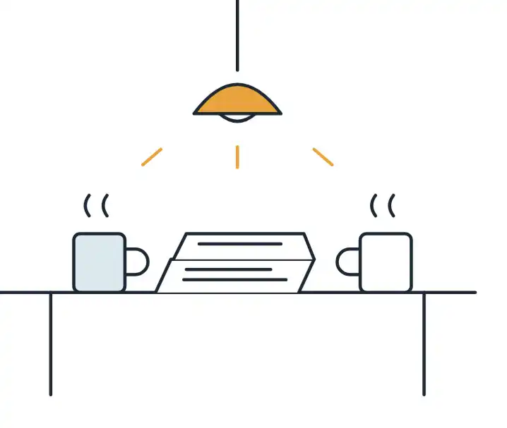 Two mugs and papers on a desk under a lamp